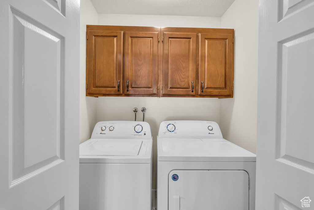 Laundry room featuring cabinets, hookup for a washing machine, and washing machine and clothes dryer