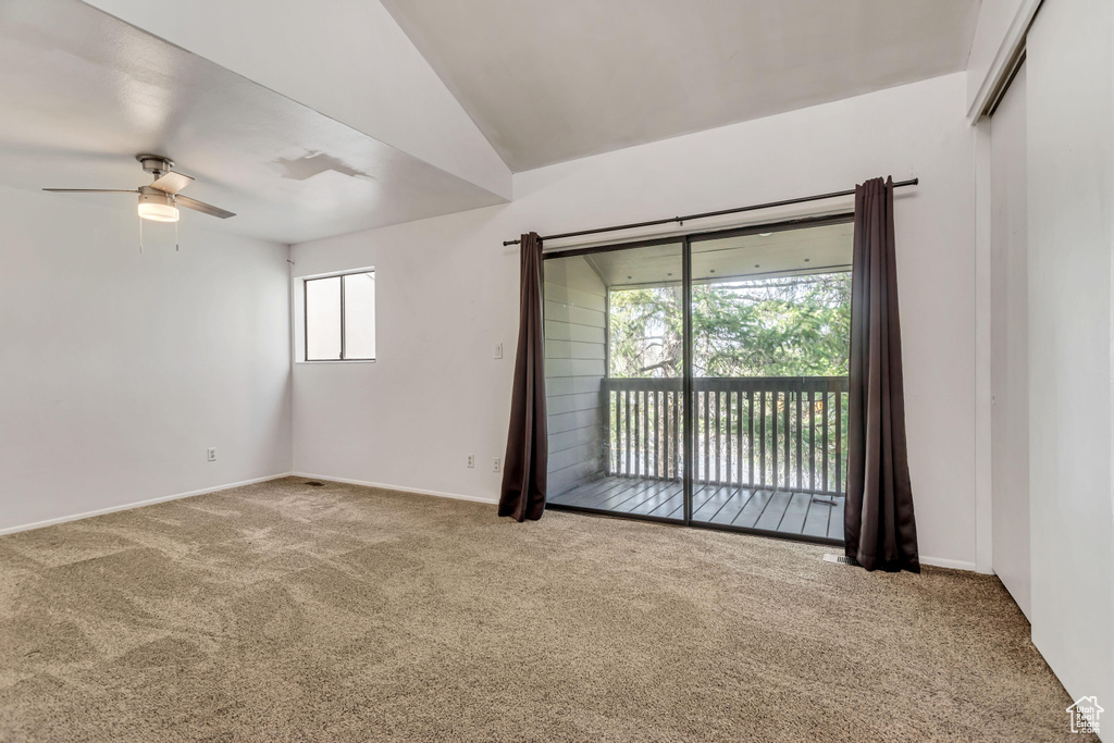 Unfurnished room featuring carpet, ceiling fan, and lofted ceiling