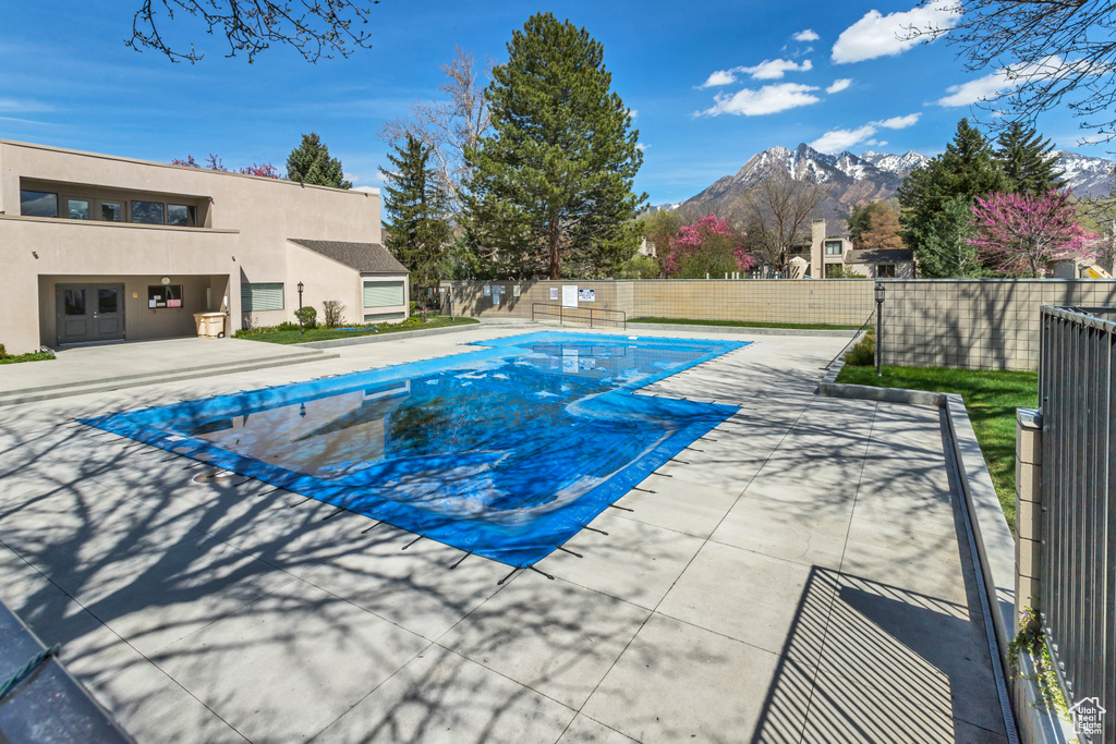 View of pool with a patio area and a mountain view