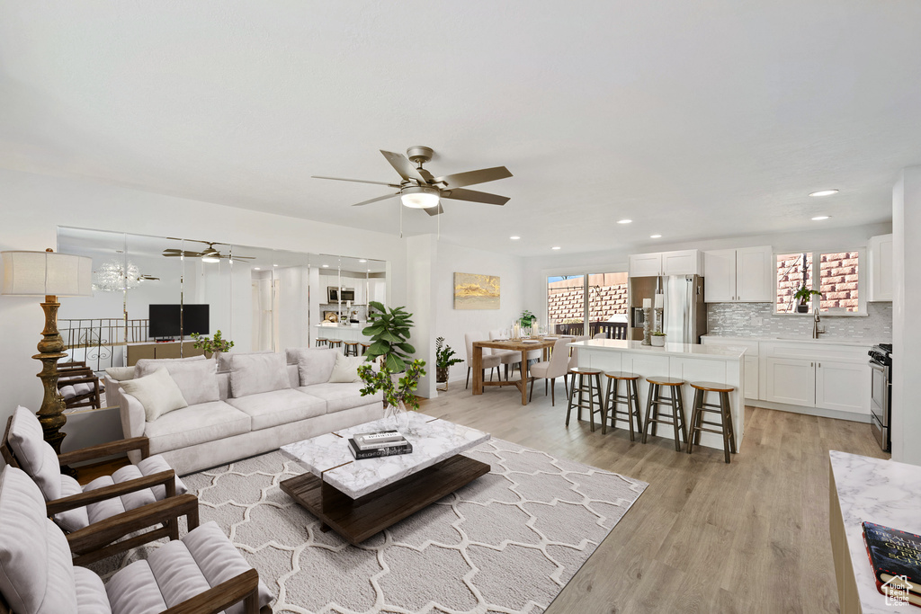 Living room featuring light hardwood / wood-style floors, ceiling fan, and sink
