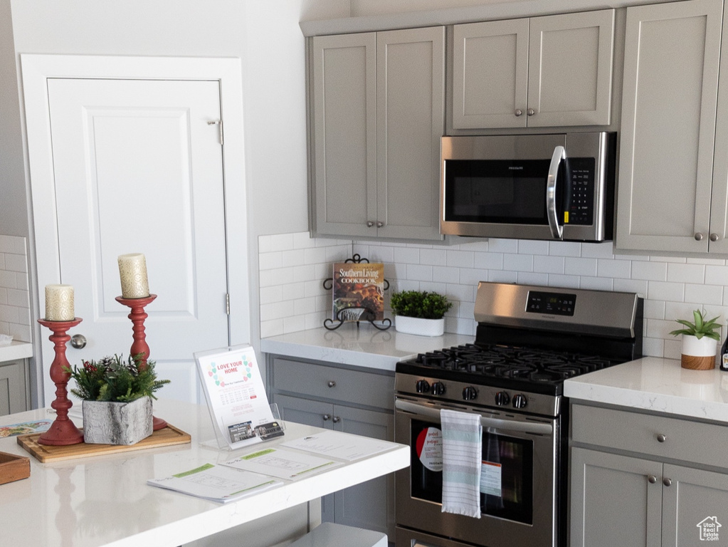 Kitchen featuring backsplash, stainless steel appliances, and dark hardwood / wood-style flooring