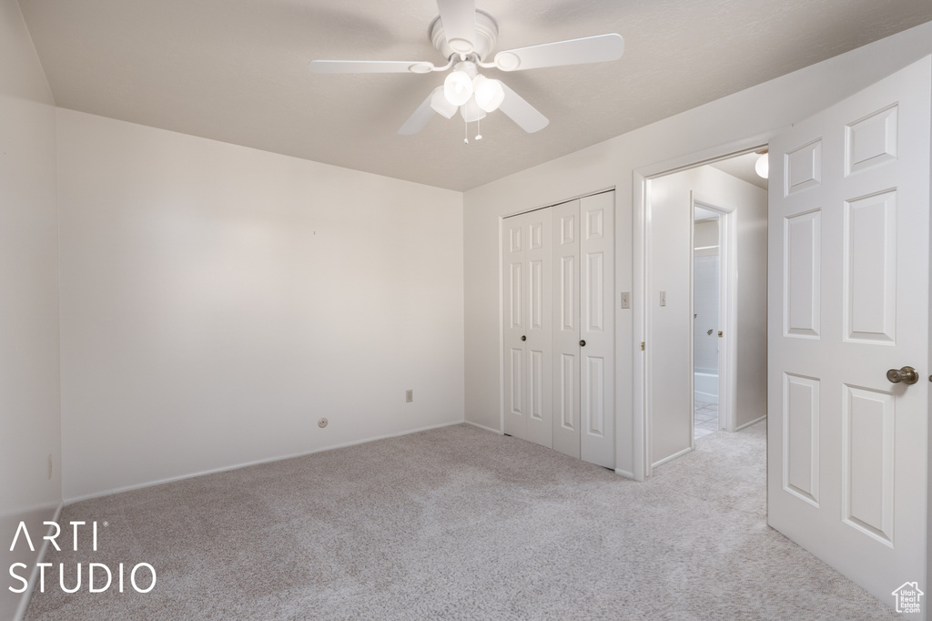 Unfurnished bedroom with light colored carpet, a closet, and ceiling fan