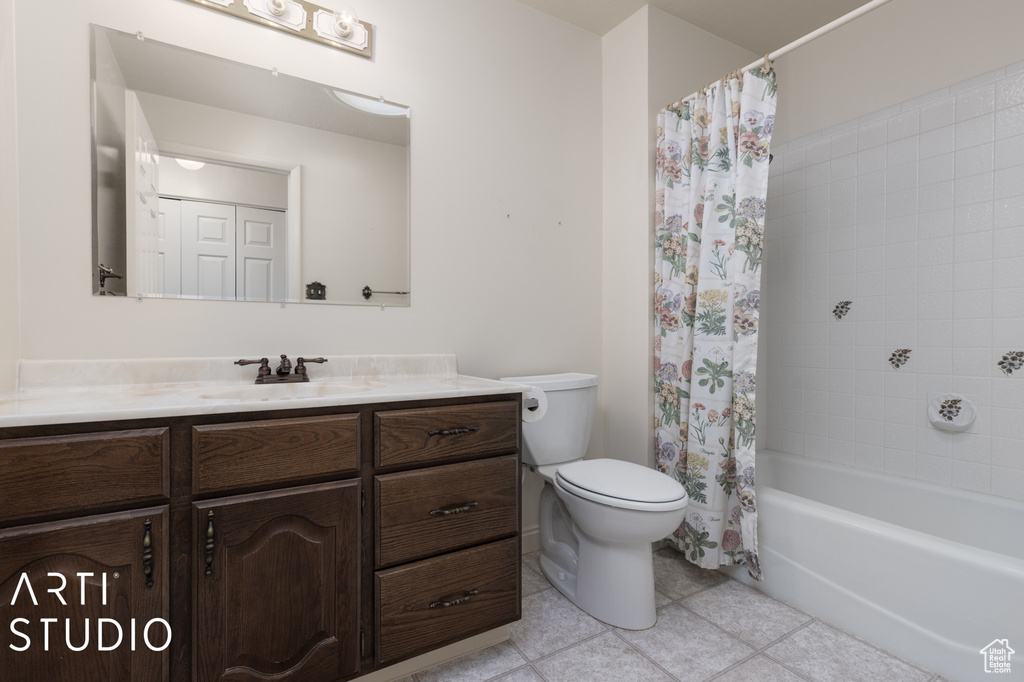 Full bathroom with toilet, tile flooring, shower / bath combo with shower curtain, and large vanity