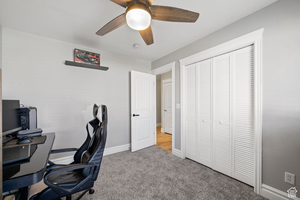 Office with ceiling fan and light carpet