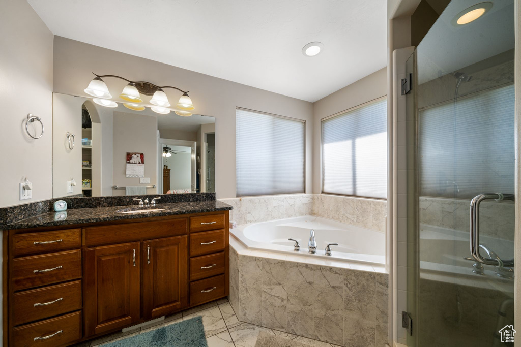 Bathroom featuring tile flooring, shower with separate bathtub, and large vanity