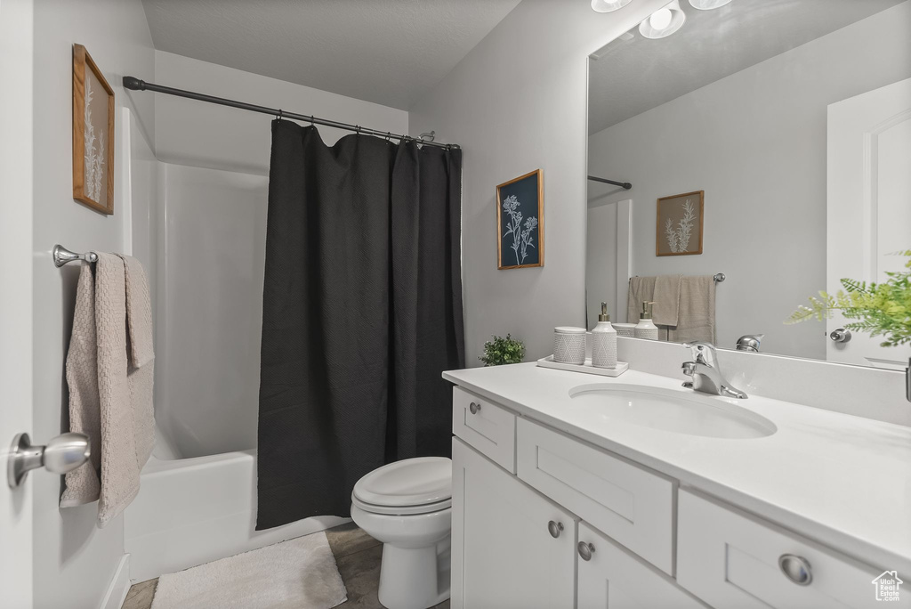 Full bathroom featuring shower / tub combo with curtain, large vanity, toilet, and tile flooring