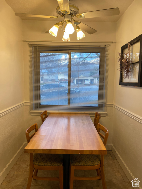 Dining area with ceiling fan and dark tile floors