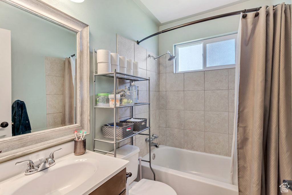 Full bathroom featuring shower / tub combo, vanity, and toilet