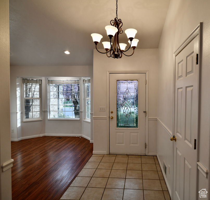 Foyer featuring light tile floors and an inviting chandelier
