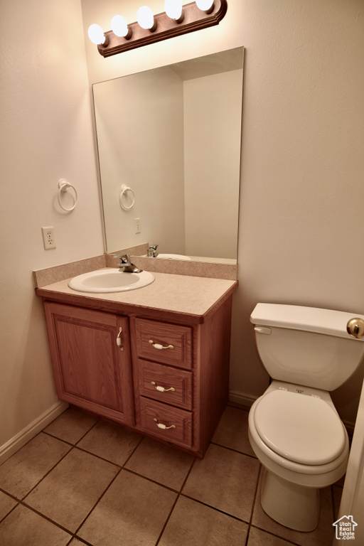Bathroom featuring large vanity, toilet, and tile flooring