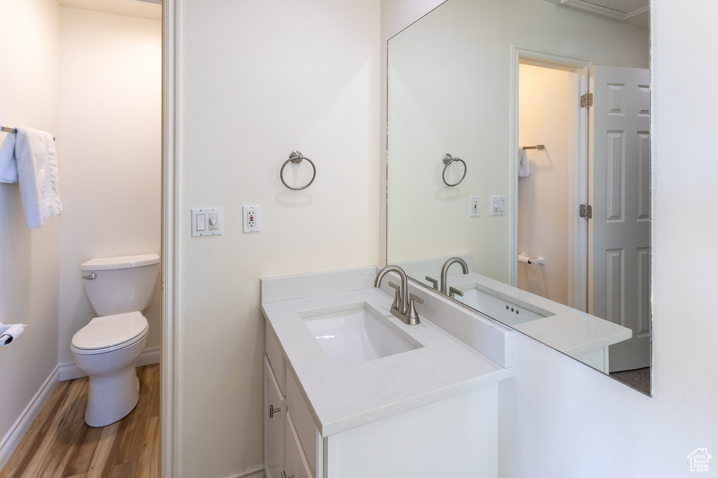 Bathroom featuring toilet, vanity, and hardwood / wood-style floors