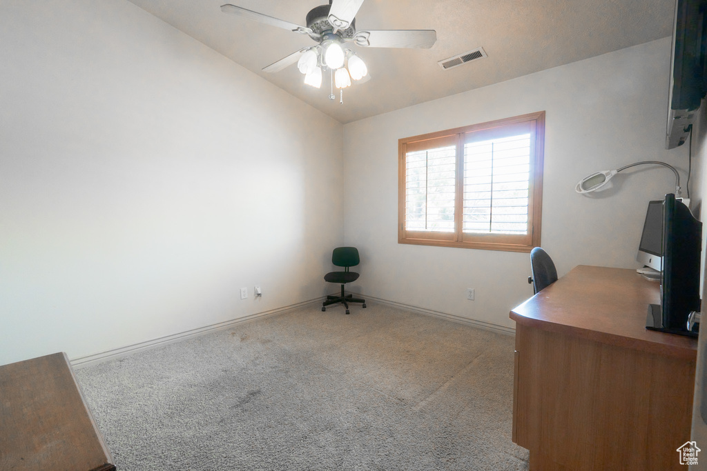 Carpeted home office with lofted ceiling and ceiling fan