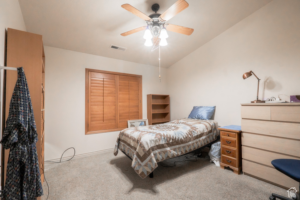 Bedroom with vaulted ceiling, ceiling fan, and light carpet