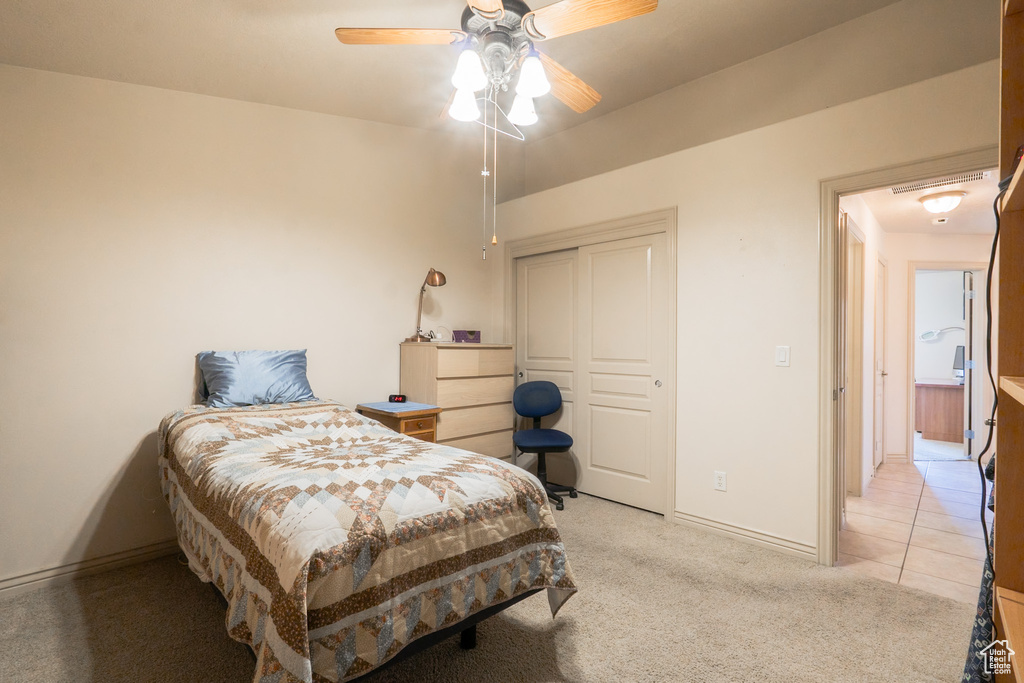 Bedroom featuring a closet, light carpet, and ceiling fan