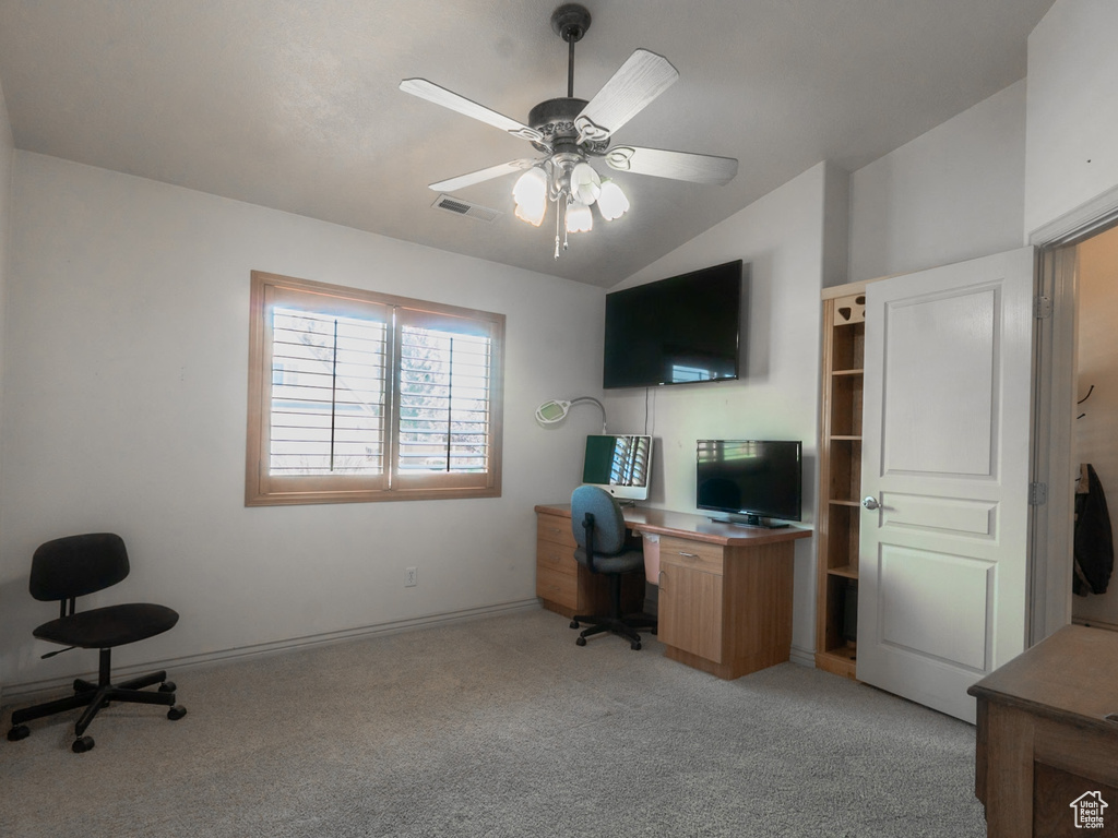 Carpeted home office with vaulted ceiling and ceiling fan