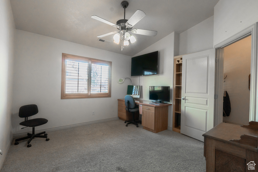 Carpeted home office with ceiling fan and lofted ceiling