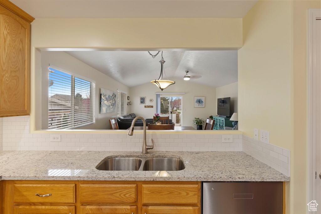 Kitchen featuring backsplash, lofted ceiling, sink, and plenty of natural light
