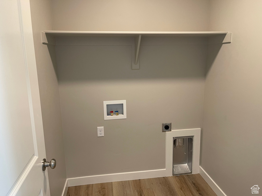Laundry area with dark hardwood / wood-style flooring, hookup for an electric dryer, and washer hookup