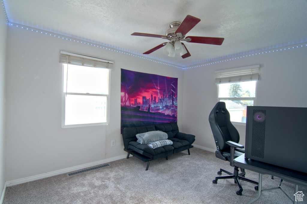 Home office with ceiling fan and carpet