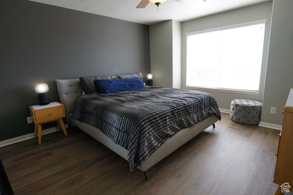 Bedroom featuring multiple windows, ceiling fan, and dark wood-type flooring