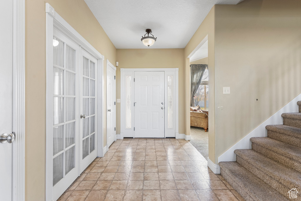Entryway with french doors and light tile flooring