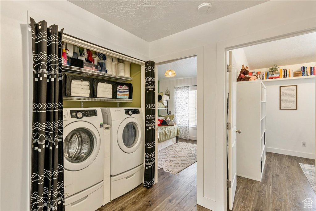 Clothes washing area featuring dark hardwood / wood-style floors and washing machine and dryer
