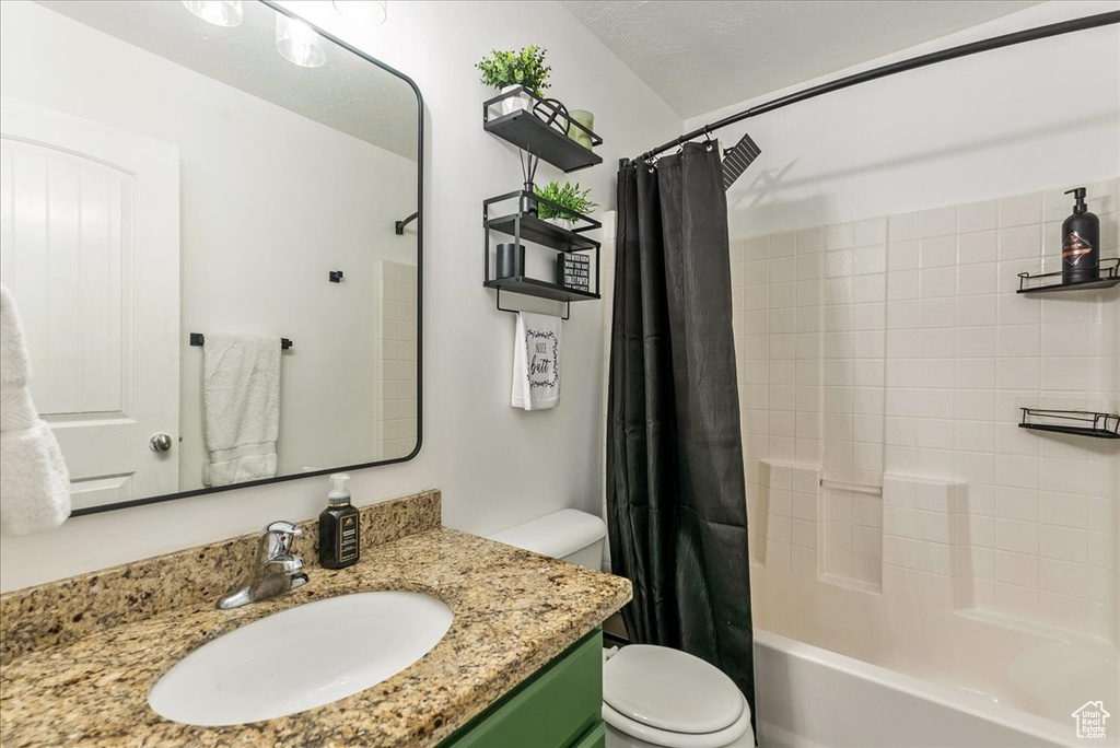 Full bathroom featuring vanity, toilet, and shower / tub combo with curtain
