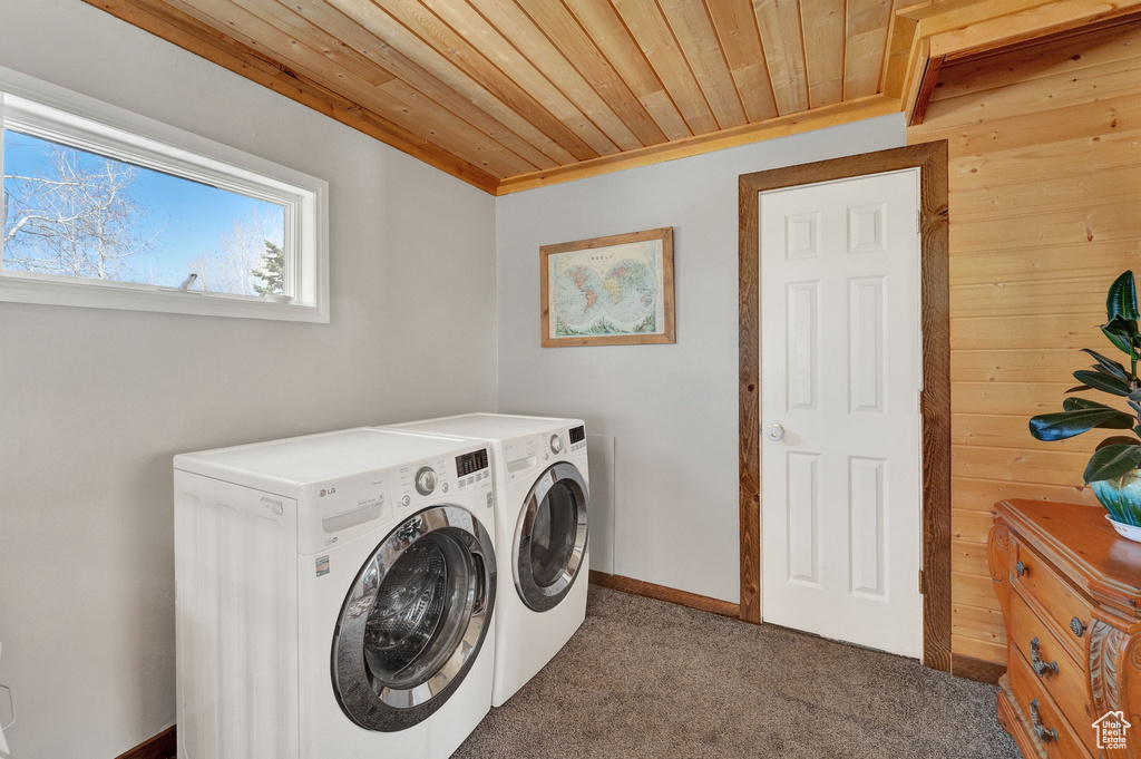 Laundry area with dark colored carpet, wooden ceiling, and washer and dryer