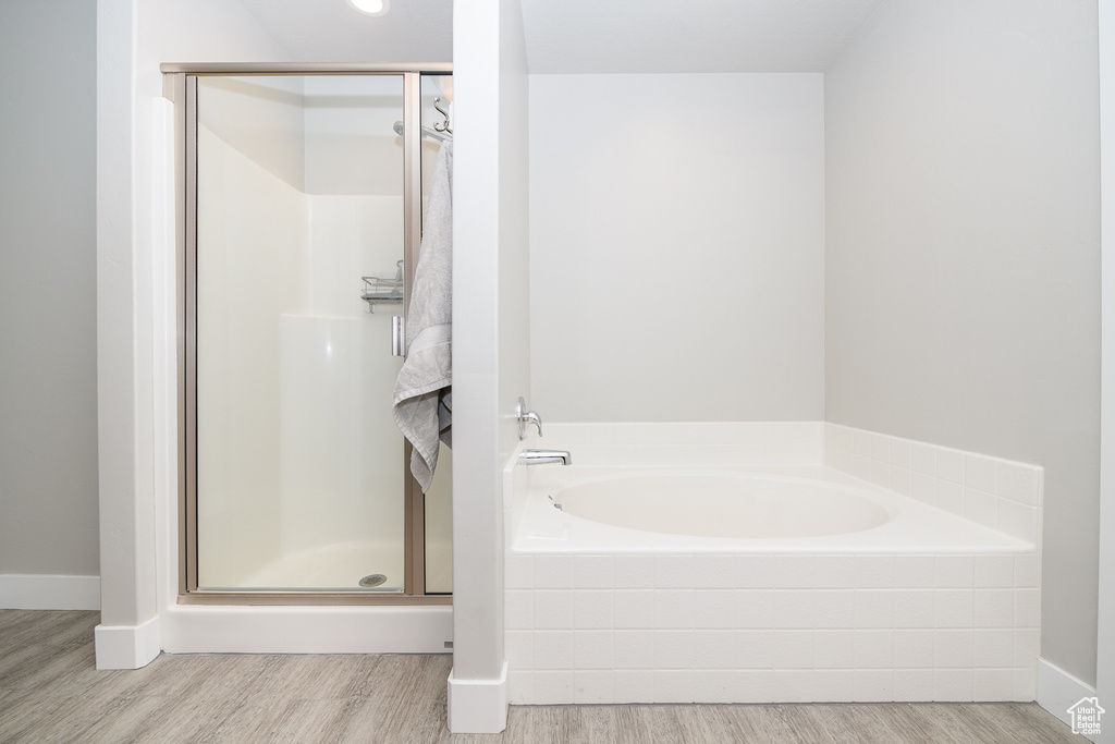 Bathroom featuring shower with separate bathtub and hardwood / wood-style flooring