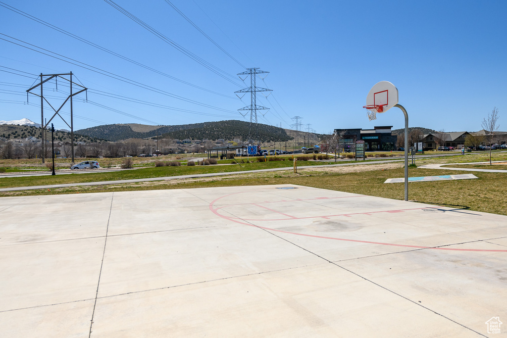 View of basketball court featuring a mountain view and a yard