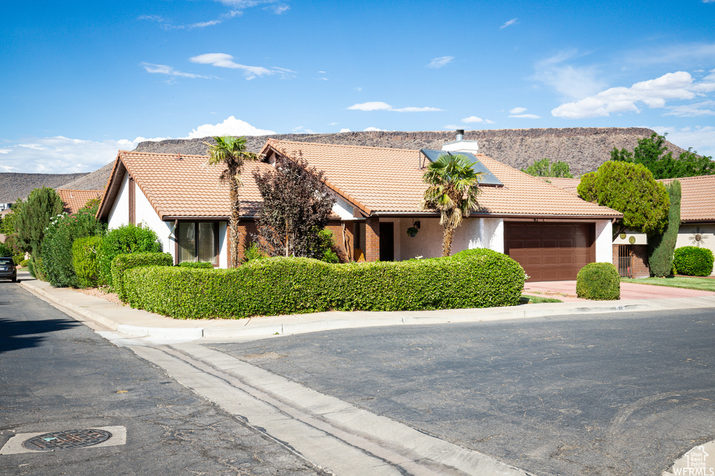 View of front of property with a mountain view and a garage