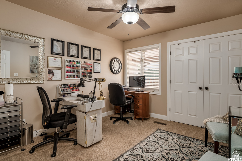 Carpeted office featuring ceiling fan