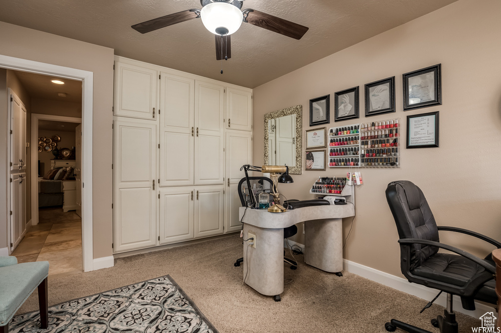 Carpeted office featuring ceiling fan