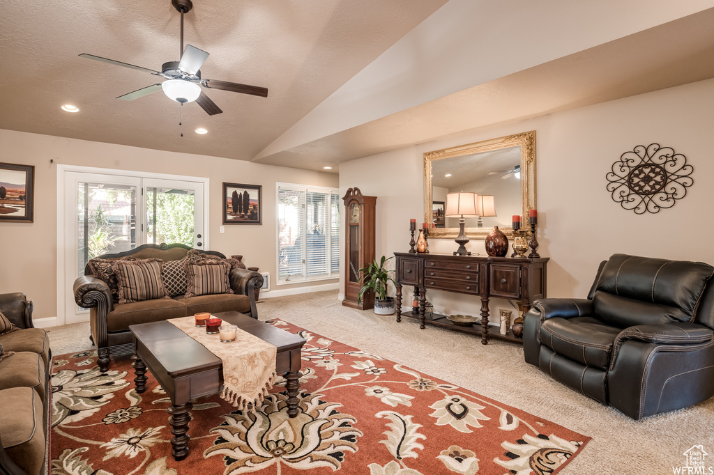 Living room featuring light colored carpet, ceiling fan, and vaulted ceiling