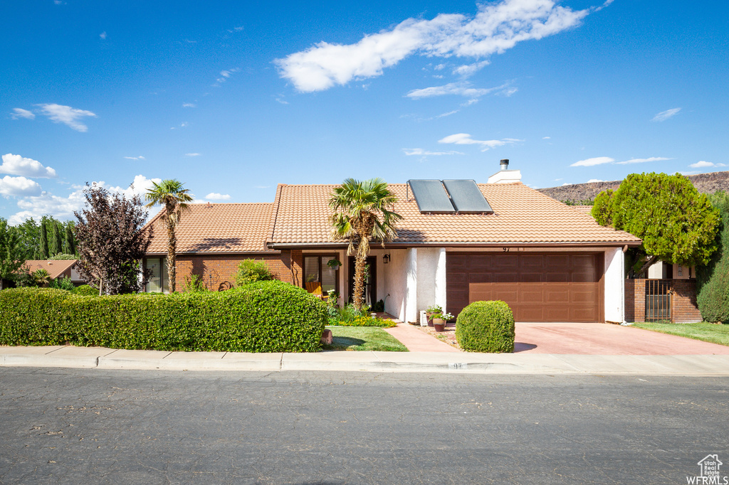 View of front of house featuring solar panels and a garage