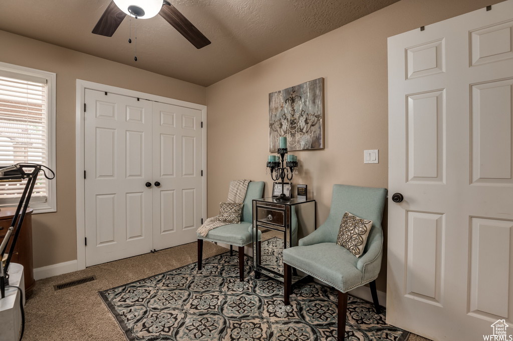 Sitting room featuring light carpet and ceiling fan