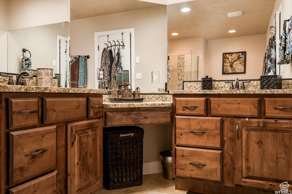 Bathroom featuring tile floors, a textured ceiling, and double sink vanity