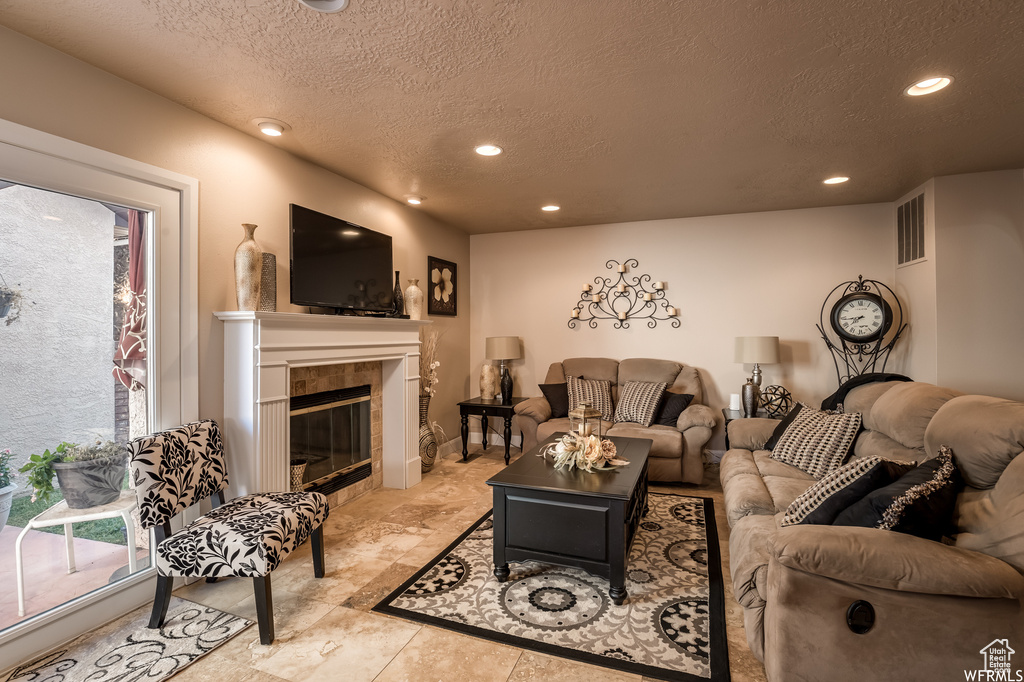 Tiled living room with a tiled fireplace and a textured ceiling