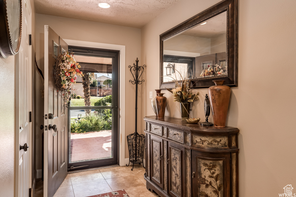 Foyer entrance featuring a textured ceiling and light tile floors