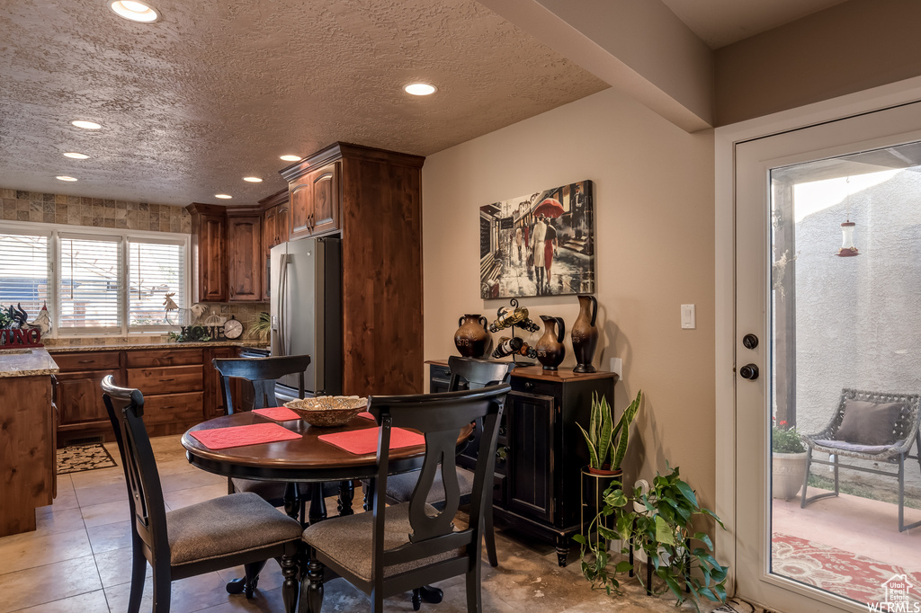 Tiled dining space featuring a textured ceiling