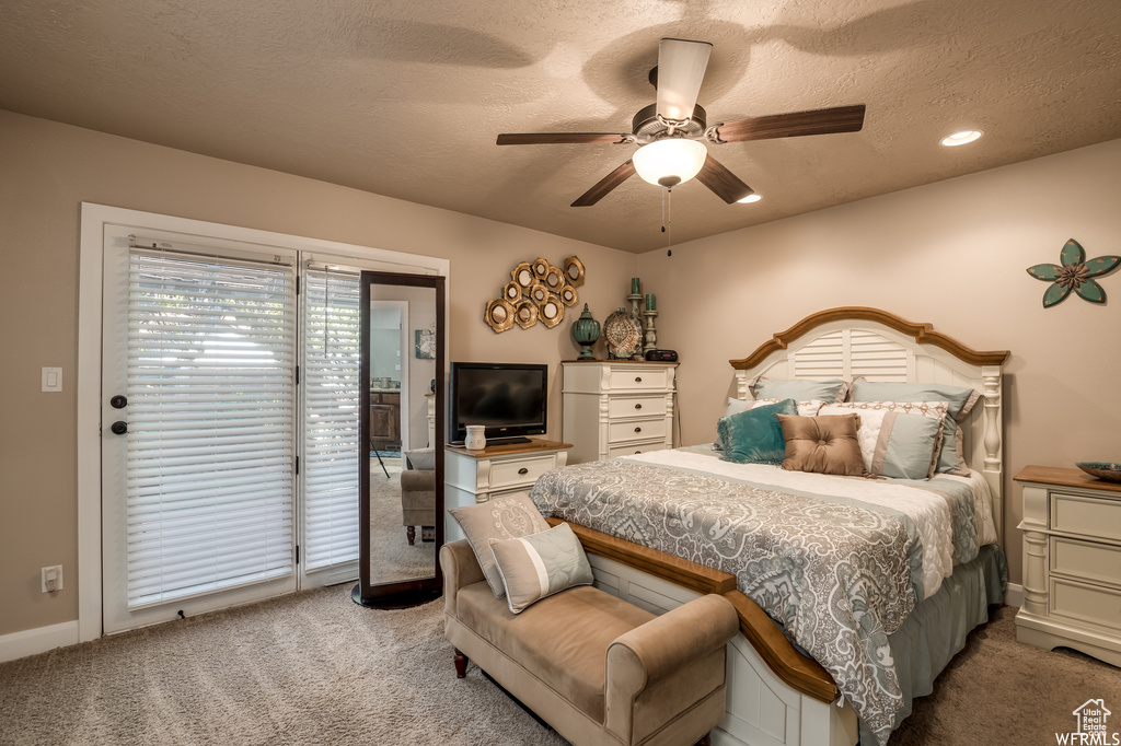 Carpeted bedroom featuring a textured ceiling, ceiling fan, and access to exterior