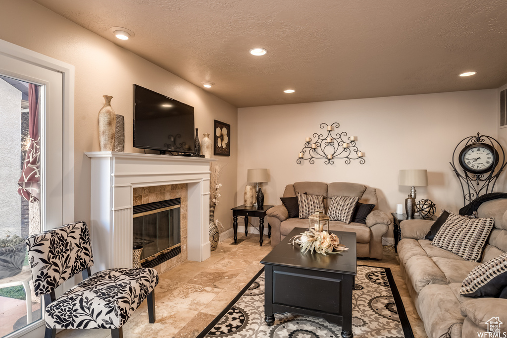 Tiled living room featuring a textured ceiling and a tile fireplace