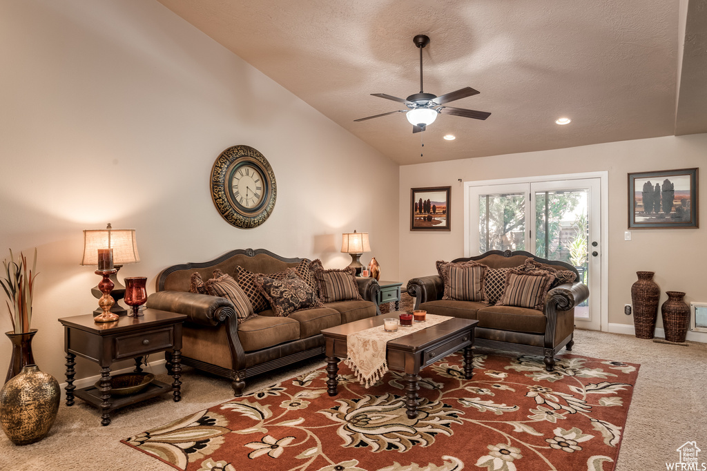 Carpeted living room with lofted ceiling and ceiling fan