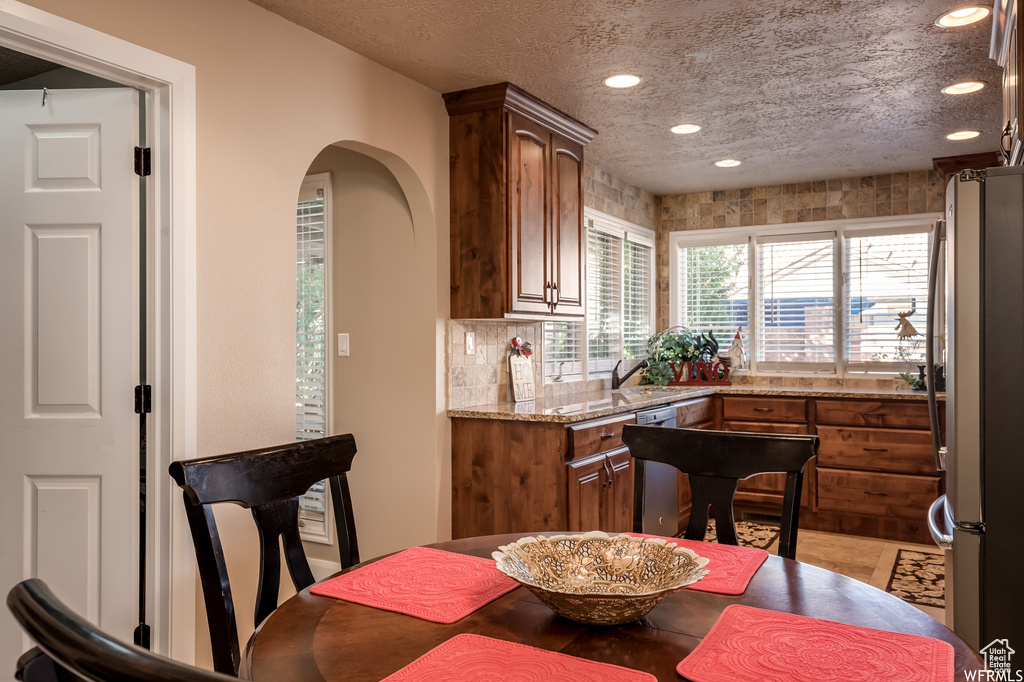 Dining space with tile flooring and a textured ceiling