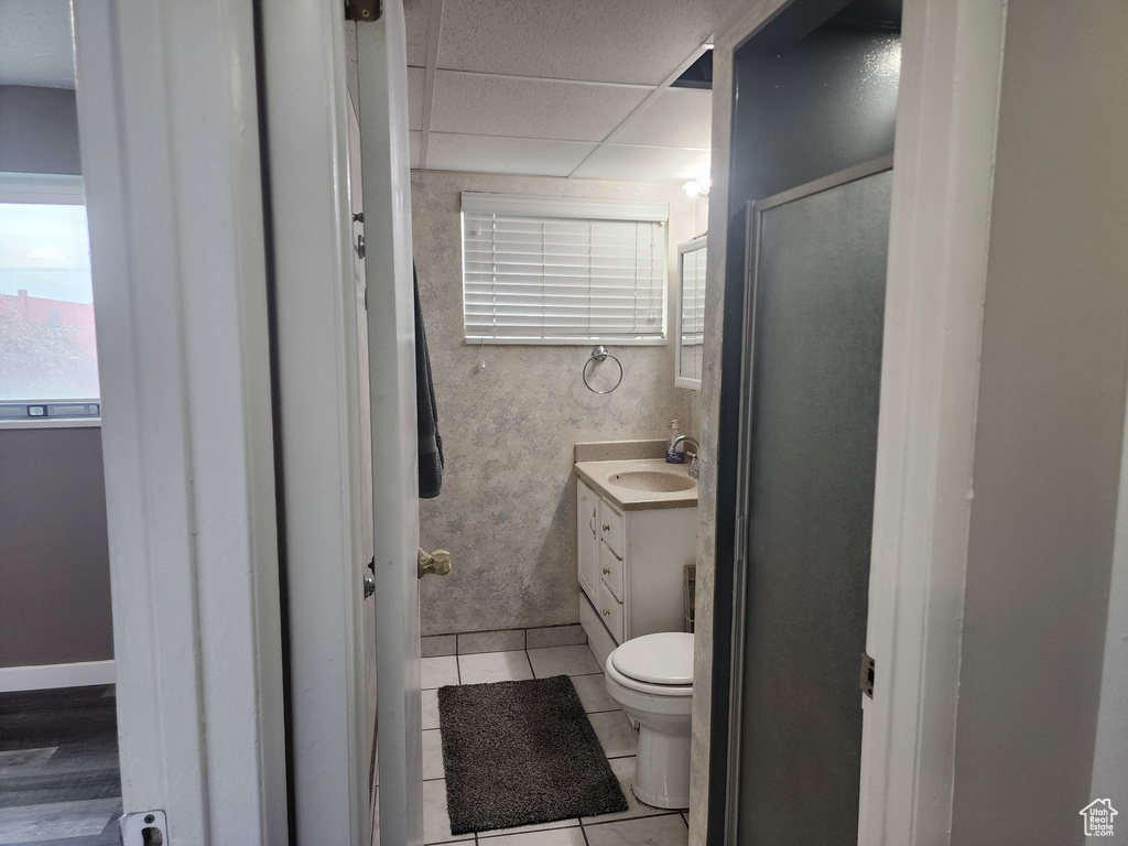 Bathroom featuring a drop ceiling, large vanity, tile floors, and toilet
