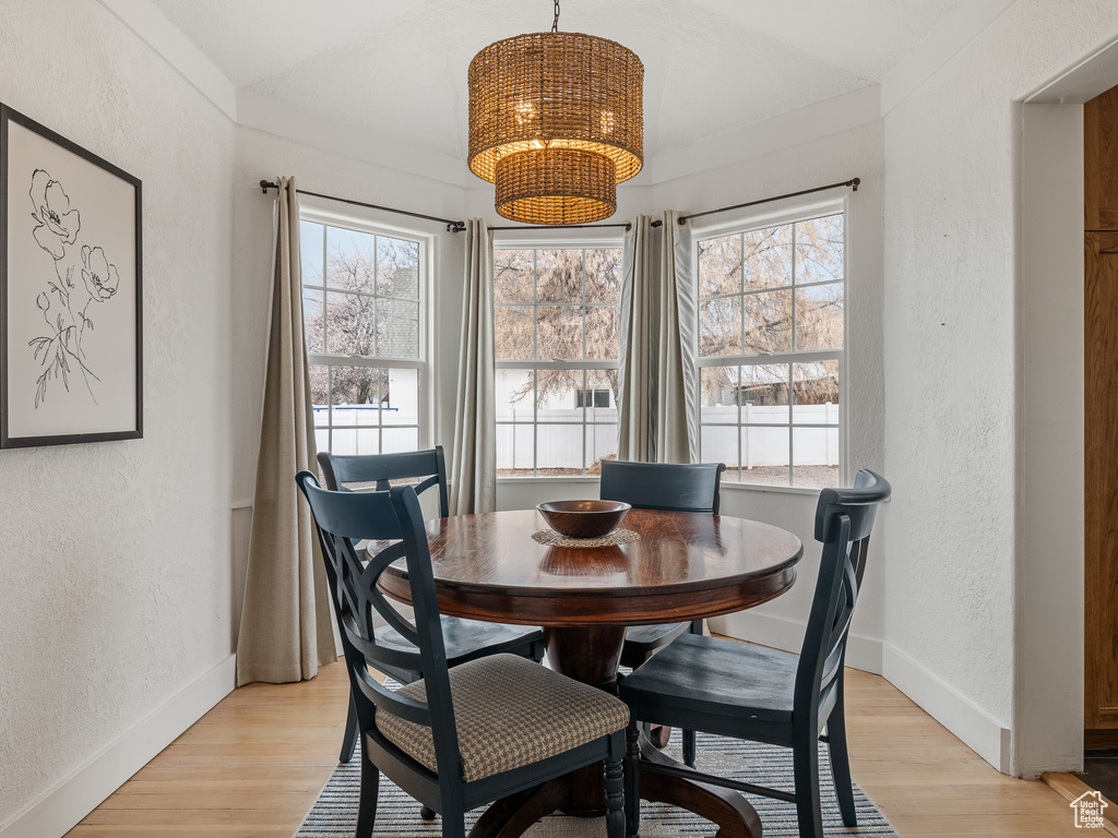 Dining room with a chandelier, light hardwood / wood-style floors, and a healthy amount of sunlight