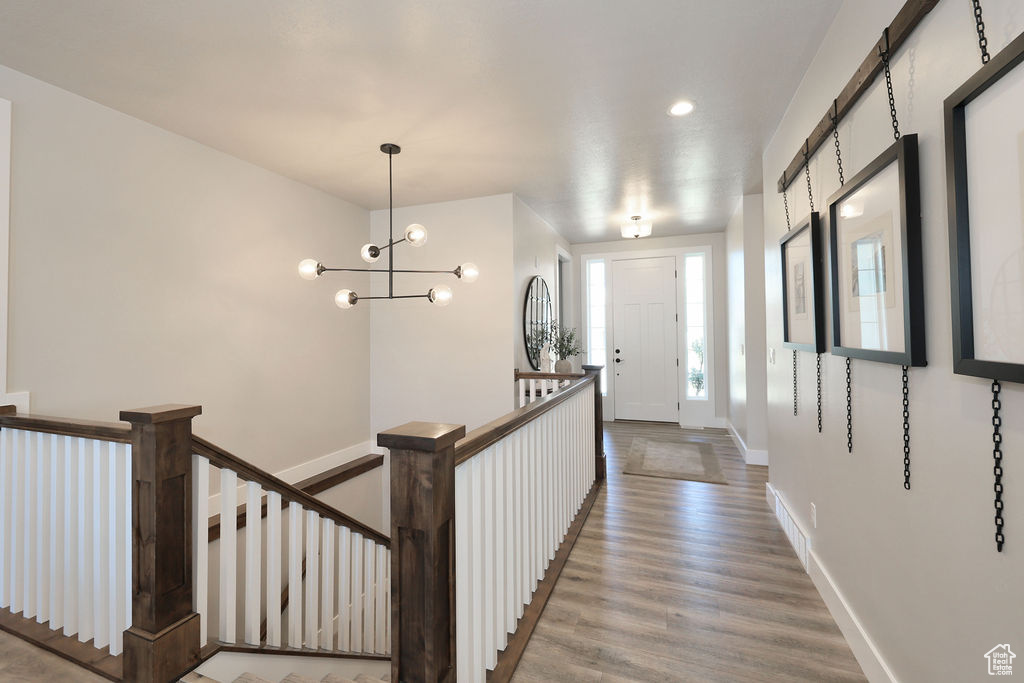 Hallway with a chandelier and hardwood / wood-style flooring