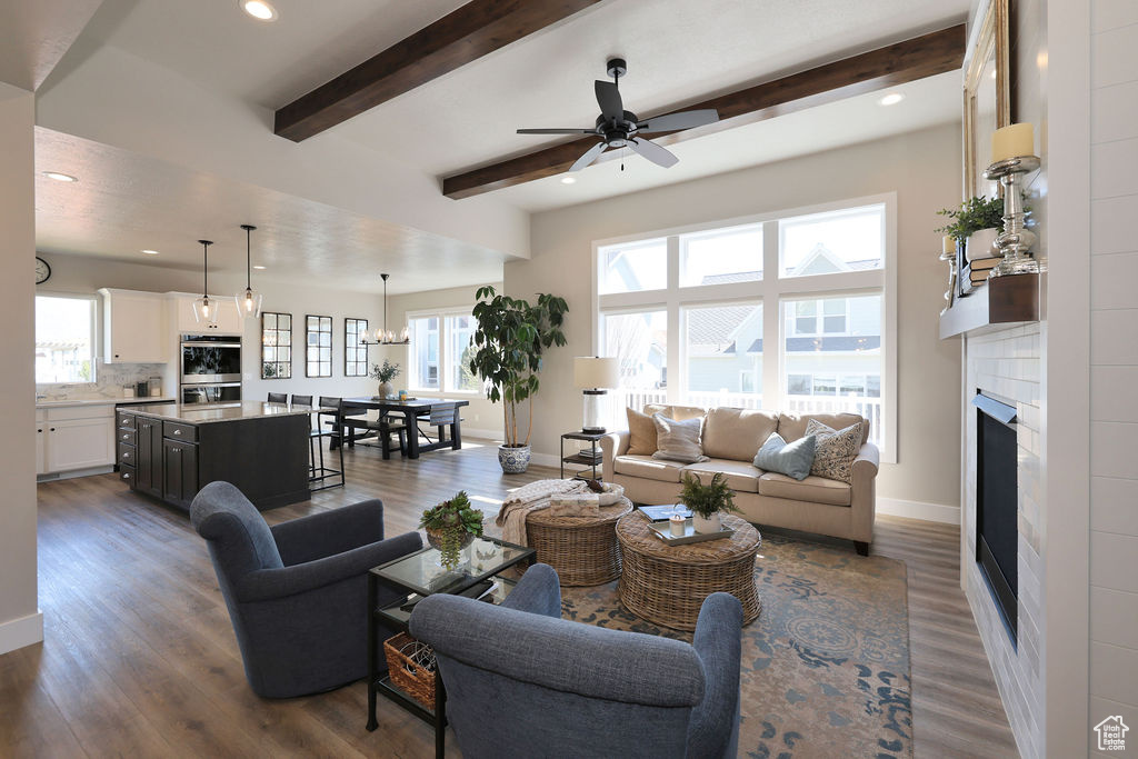 Living room featuring ceiling fan, dark hardwood / wood-style floors, and beam ceiling