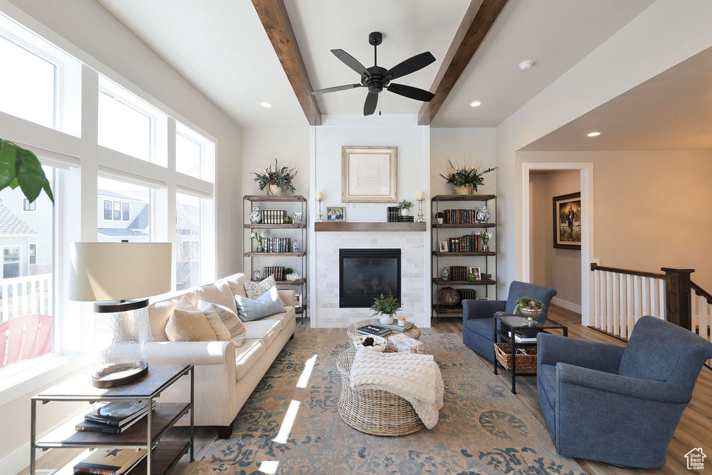 Living room with dark hardwood / wood-style flooring, beam ceiling, and ceiling fan