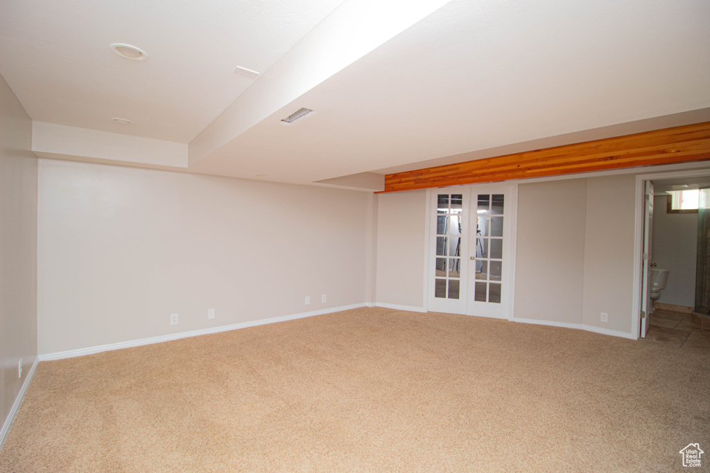 Basement with light colored carpet and french doors